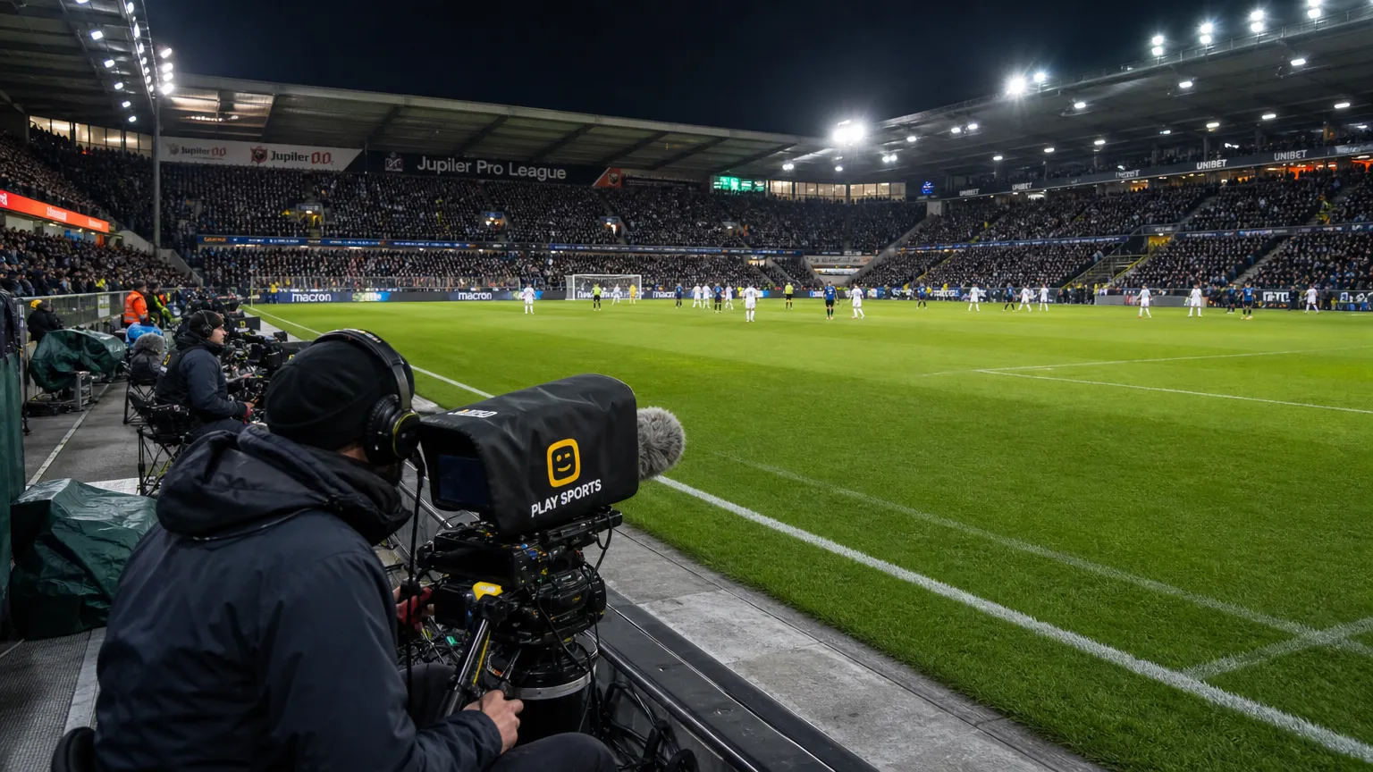 Televisiecamera’s langs het veld in een gevuld Belgisch voetbalstadion