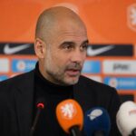 Pep Guardiola tijdens een geconcentreerd persmoment in voetbalcontext