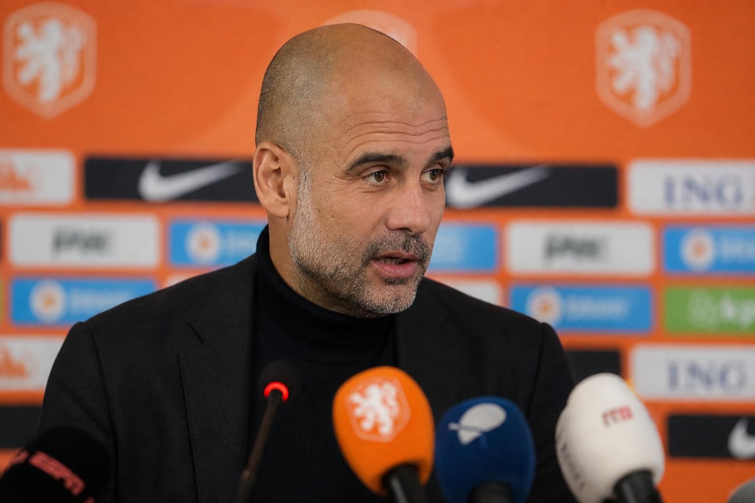 Pep Guardiola tijdens een geconcentreerd persmoment in voetbalcontext