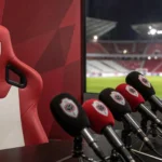 Een gespannen perszaal in een voetbalstadion als symbool voor de trainerskeuze van Royal Antwerp FC