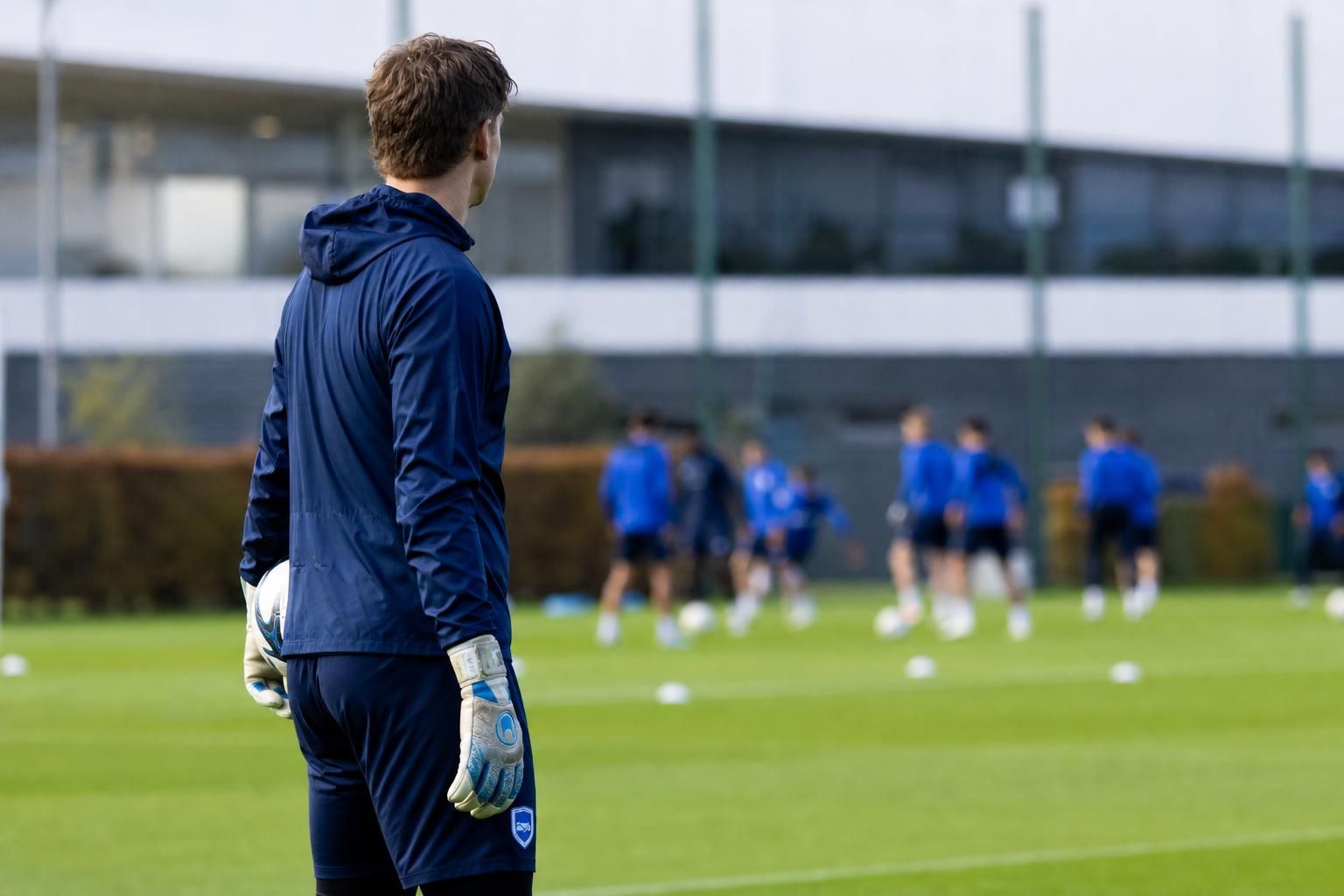Keeperhandschoenen op het trainingsveld als symbool voor de contractverlenging van Lucca Brughmans bij KRC Genk.