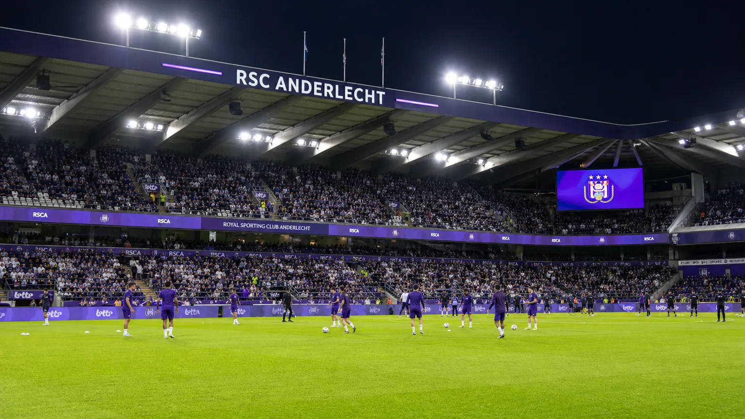 Brede wedstrijddagscène in het stadion van RSC Anderlecht met spelers tijdens de opwarming