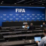 Brede blik op een FIFA-mediacentrum met werkende journalisten en een leeg perspodium