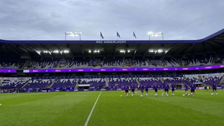 Lotto Park tijdens een wedstrijddag met spelers die in de verte opwarmen