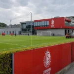 Het trainingscomplex van Standard Luik met medewerkers en spelers op de achtergrond