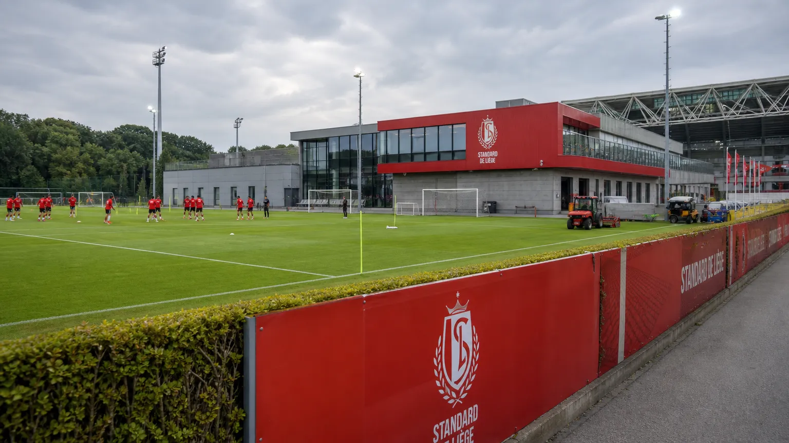 Het trainingscomplex van Standard Luik met medewerkers en spelers op de achtergrond