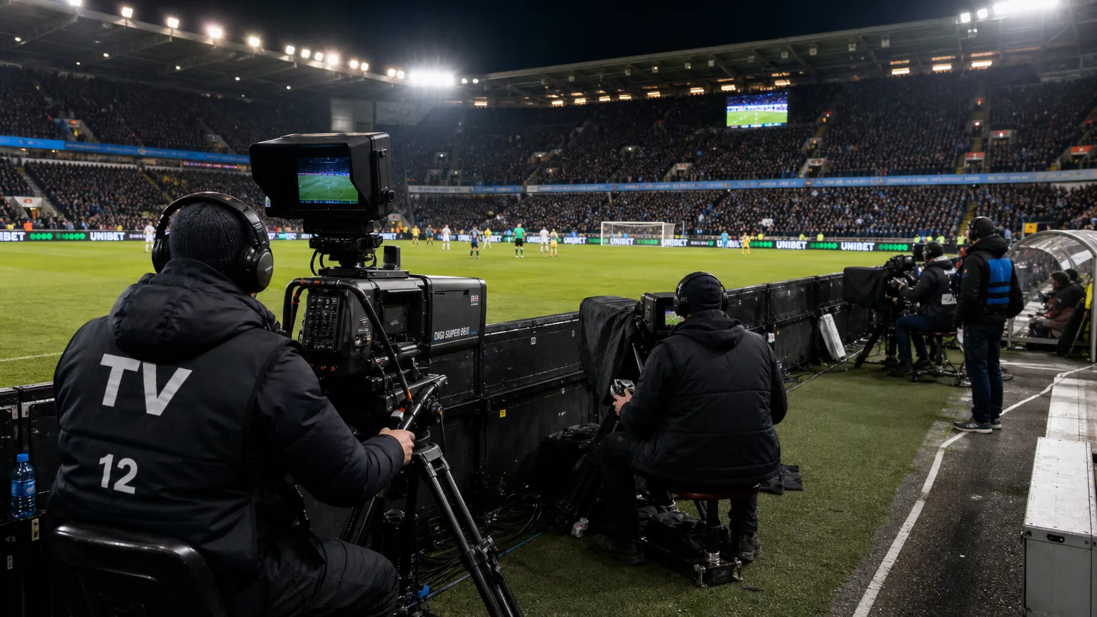 Televisiecamera’s langs het veld in een Belgisch voetbalstadion tijdens een wedstrijddag