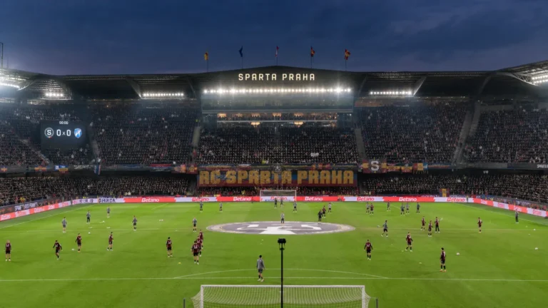 Spelers van Sparta Praag warmen in groep op in een gevuld stadion