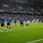 Club Brugge en Union werken in groep hun opwarming af in een gevuld stadion