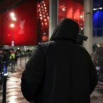 Een gespannen transfersfeer rond Liverpool en PSG bij een stadionomgeving zonder herkenbare gezichten.