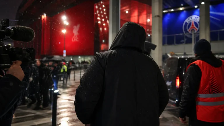 Een gespannen transfersfeer rond Liverpool en PSG bij een stadionomgeving zonder herkenbare gezichten.