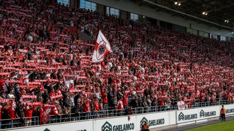 Supporters van Royal Antwerp FC in rood-witte clubkleuren op de Bosuil