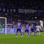 Spelers van Sanfrecce Hiroshima in een brede wedstrijdscène rond het doel