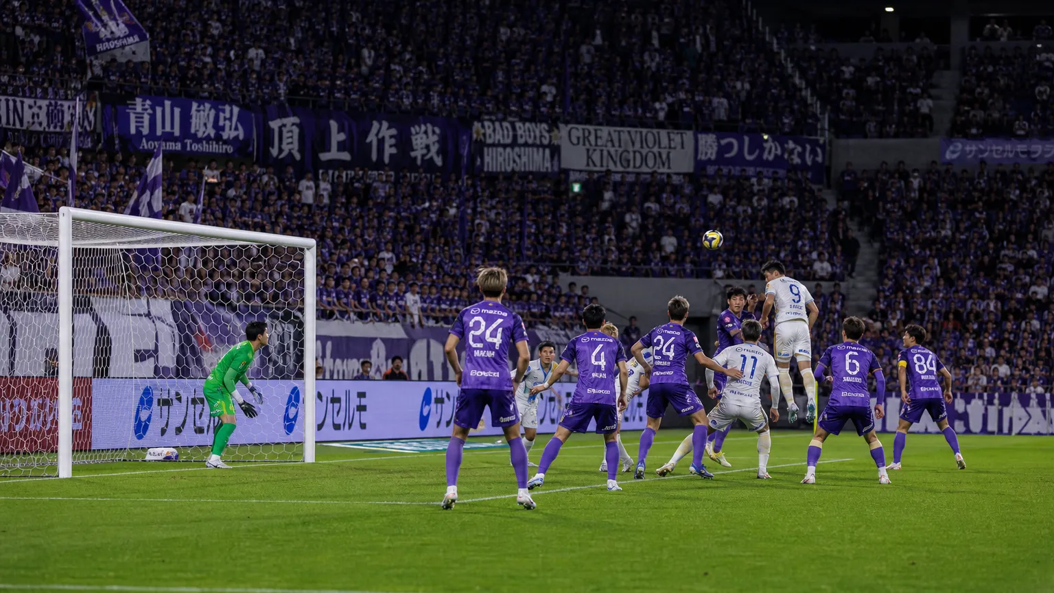 Spelers van Sanfrecce Hiroshima in een brede wedstrijdscène rond het doel