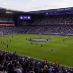 Gevulde tribunes en spelersgroepen tijdens de wedstrijdvoorbereiding in het Lotto Park