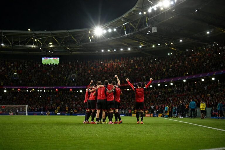 Rode Duivels vieren een doelpunt in een WK-stadion zonder herkenbare gezichten.