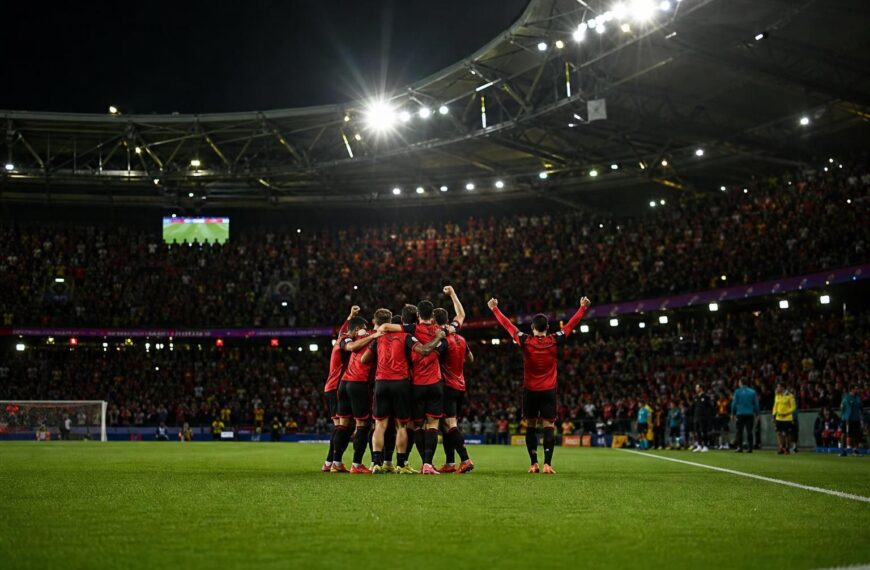 Rode Duivels vieren een doelpunt in een WK-stadion zonder herkenbare gezichten.
