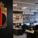 Mediawerkruimte in een kantoor van de KBVB met het bondslogo aan de muur