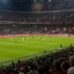 Brede wedstrijddagscène in het stadion van AC Milan met rood-zwarte supporters