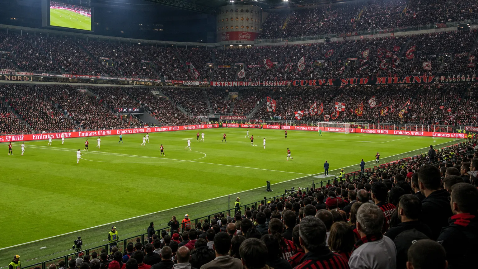 Brede wedstrijddagscène in het stadion van AC Milan met rood-zwarte supporters