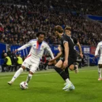 Brede wedstrijdscène met niet-herkenbare spelers van Olympique Lyon op het veld.