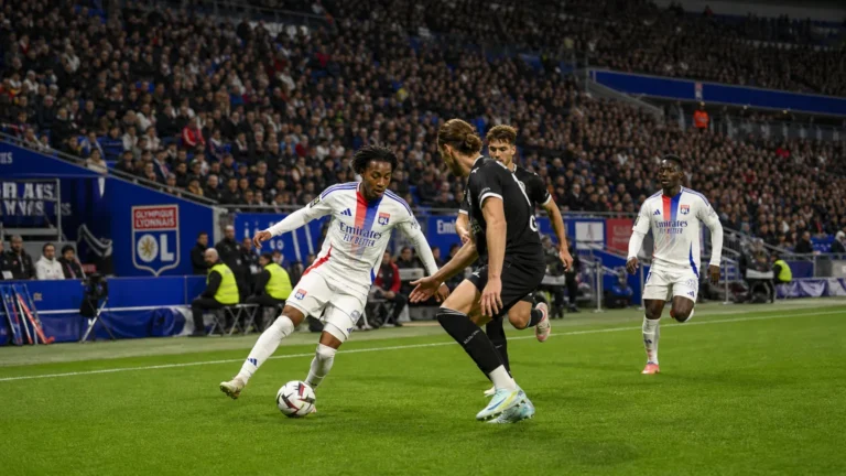 Brede wedstrijdscène met niet-herkenbare spelers van Olympique Lyon op het veld.