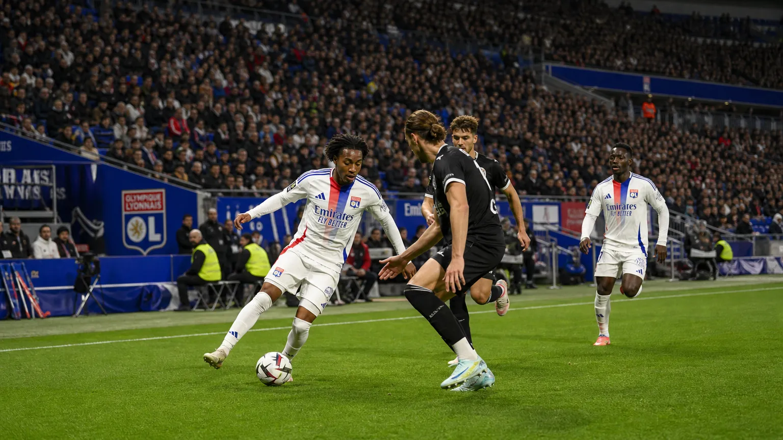 Brede wedstrijdscène met niet-herkenbare spelers van Olympique Lyon op het veld.