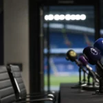 Persruimte in een voetbalstadion met microfoons en gespannen sfeer rond disciplinaire maatregelen.