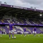 Niet-herkenbare Beerschot-spelers warmen op in het Olympisch Stadion.