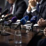 Een gespannen persmoment rond internationale voetbalbestuurders en FIFA-discussie zonder herkenbare gezichten