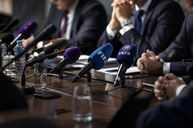 Een gespannen persmoment rond internationale voetbalbestuurders en FIFA-discussie zonder herkenbare gezichten