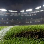 Een stukje voetbalgras met stadionlichten op de achtergrond als herinnering aan een WK-finale