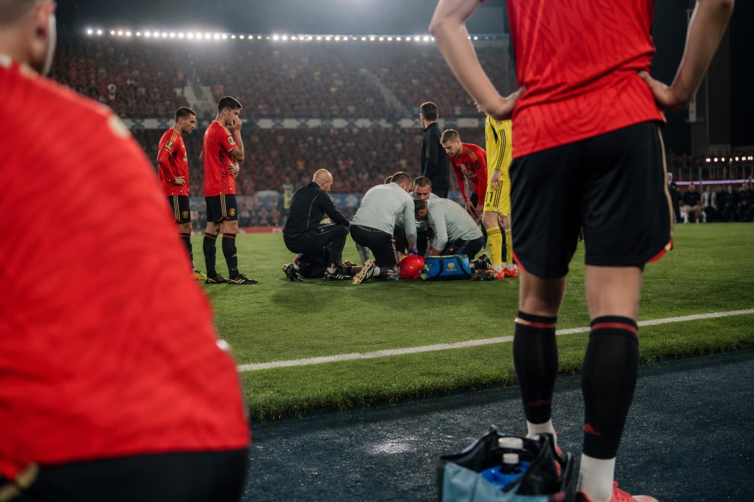 Tense stadionbeeld rond een blessuremoment bij de Rode Duivels zonder herkenbare gezichten
