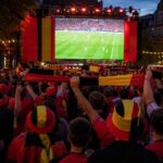 Supporters van de Rode Duivels volgen een WK-wedstrijd op een groot scherm