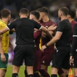 Scheidsrechtersteam bij een gespannen moment tijdens een voetbalwedstrijd