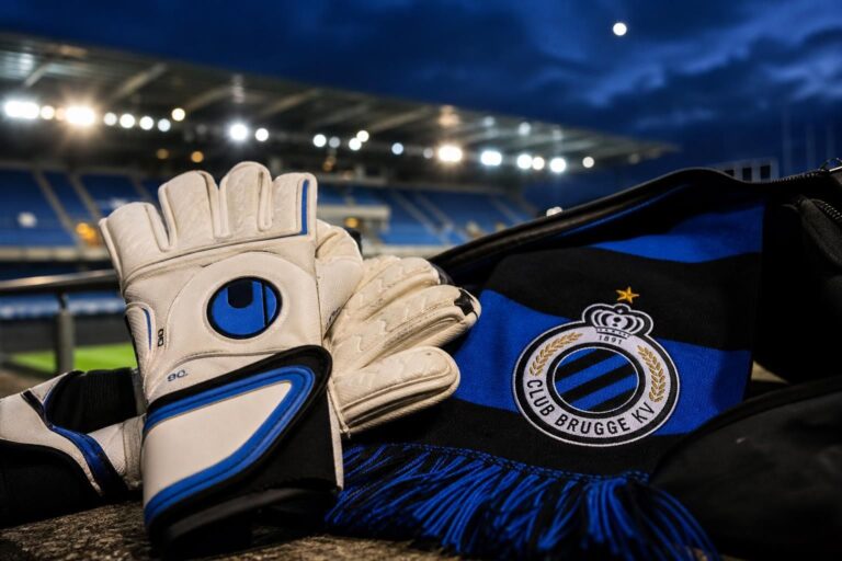 Transfercontext rond Club Brugge met keepershandschoenen en blauw-zwarte clubkleuren bij Jan Breydel.