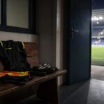 Sfeervol stadionbeeld rond een ingetogen eerbetoon aan een scheidsrechter.