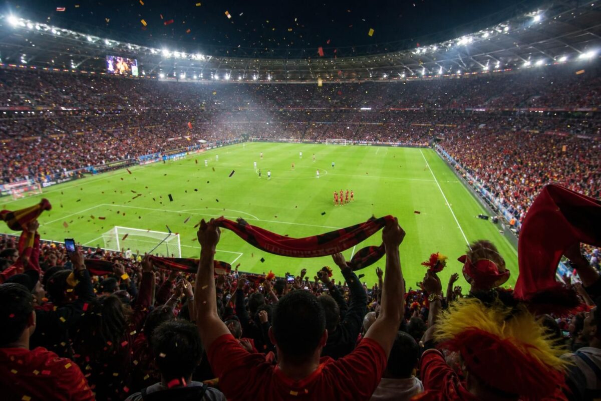 WK-stadion met spelers in actie en supporters die genieten van topvoetbal