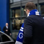 Transfercontext rond KRC Genk met een gespannen stadionomgeving zonder herkenbare personen