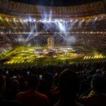 WK-finalestadion tijdens een opvallende rustshow met felle lichten en supporters op de tribunes