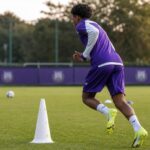 Een jonge speler van RSC Anderlecht tijdens een gefocuste trainingssituatie zonder herkenbare gezichten