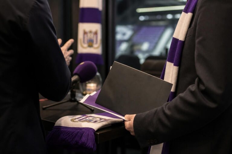 Transfercontext rond RSC Anderlecht met paarse en witte accenten, zonder herkenbare personen.