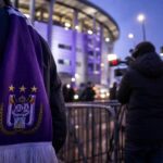 Transfercontext bij RSC Anderlecht met paarse sjaal en perscamera's zonder herkenbare gezichten