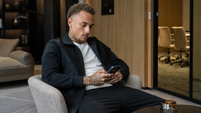 Noa Lang in neutrale sportkleding in een rustige hotellounge.