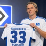 Sebastiaan Bornauw poseert tijdens zijn officiële voorstelling bij Hamburg met een HSV-shirt.