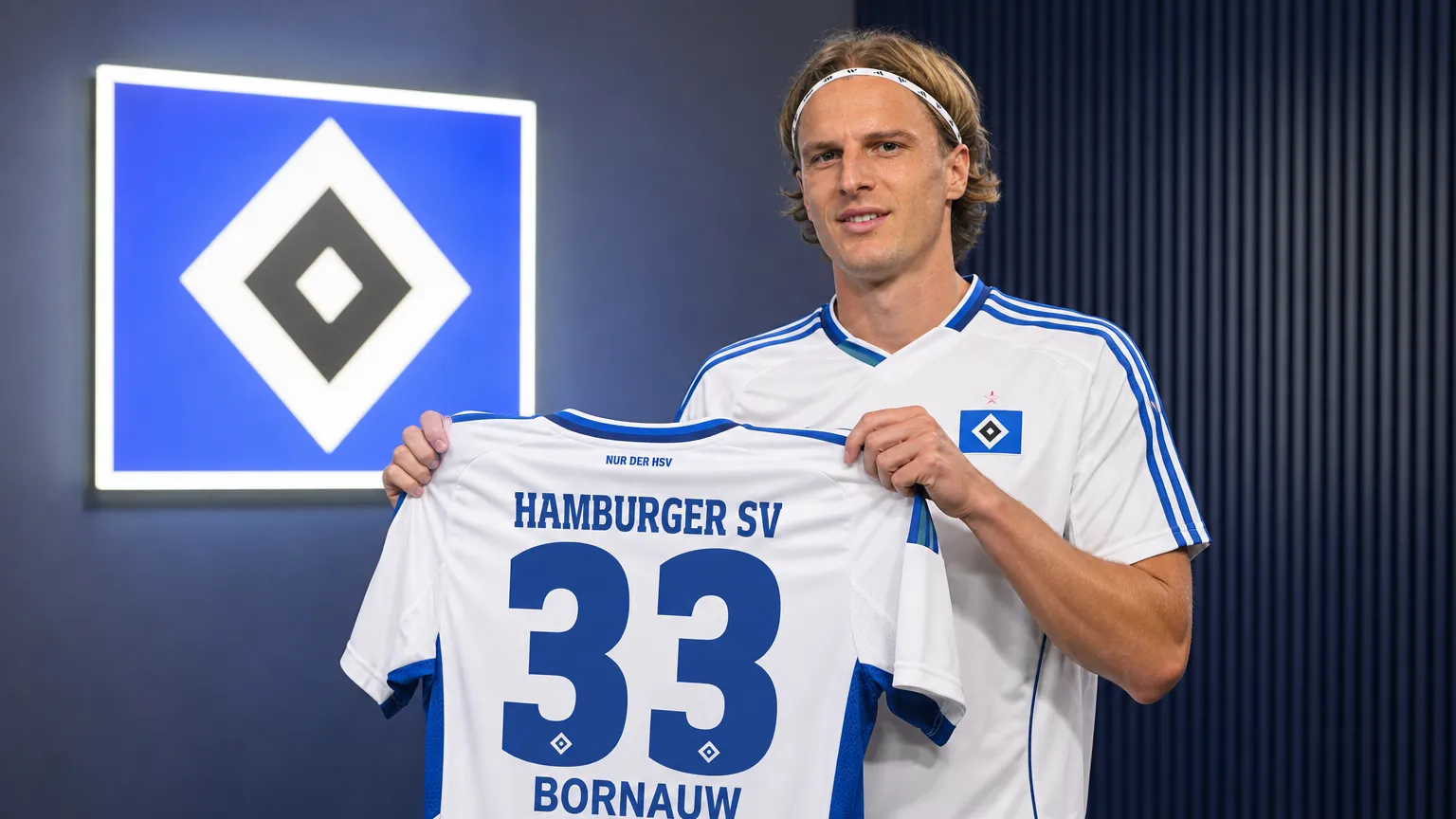 Sebastiaan Bornauw poseert tijdens zijn officiƫle voorstelling bij Hamburg met een HSV-shirt.