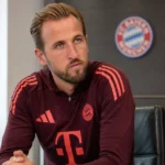 Harry Kane zit geconcentreerd in een vergaderruimte van Bayern München.