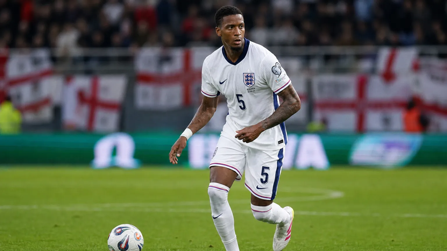 Ezri Konsa in actie in het witte tenue van Engeland tijdens een voetbalwedstrijd.