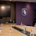 Operationele mediaruimte van Beerschot met een discreet paars clubanker aan de wand.