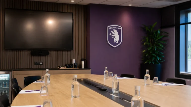 Operationele mediaruimte van Beerschot met een discreet paars clubanker aan de wand.